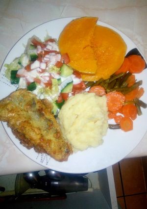 A picture of Vegetable plate with fried fish.