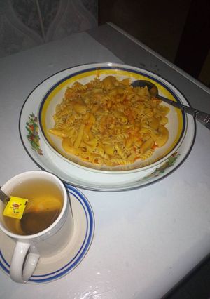 A picture of Mix macaroni jollof and black tea.