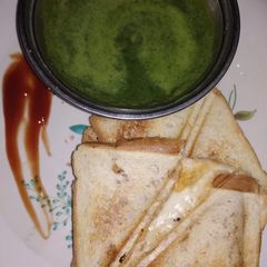 A picture of Cheese aloo sandwich with green chutney.