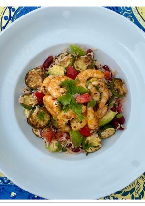 Une photo de Salade de riz, courgettes, avocat, tomate, haricots rouges et crevettes sautées