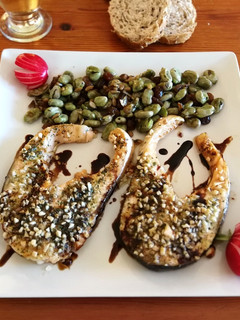 Una foto de Salmón con costra al horno con guarnición de habas baby