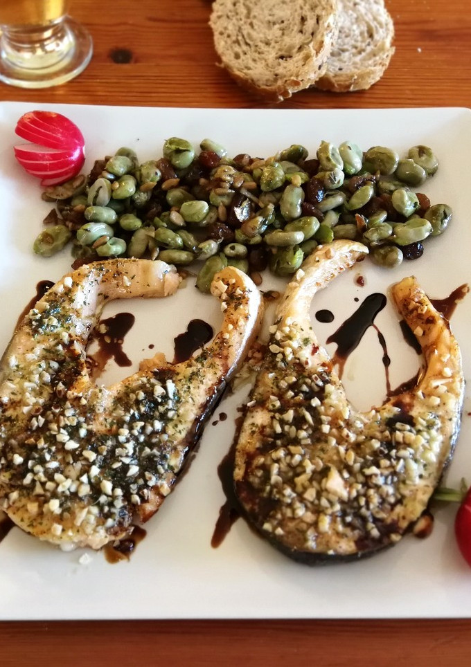 Una foto de Salmón con costra al horno con guarnición de habas baby