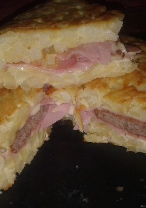 Una foto de Tortilla de papa rellena de paty, jamón y queso