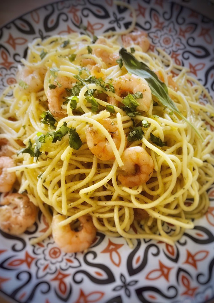 Una foto de Spaghetti al pesto de albahaca y piñones con langostinos