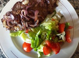 Una foto de Churrasco encebollado a la plancha con ensalada mixta
