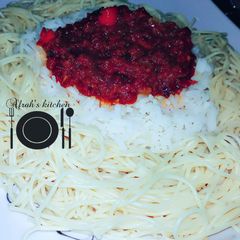 A picture of White rice and spaghetti with stew.