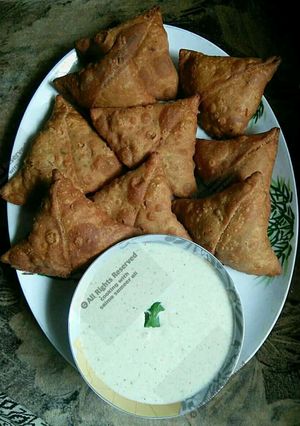 A picture of Whole wheat(gandum atta) samosay with green raita chutni.