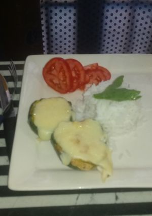 Una foto de Zapallito relleno acompañado de un timbal de arroz