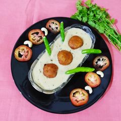 A picture of Malai kofta (in white curry).