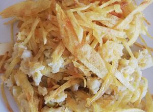 Foto principal de Revuelto de bacalao con puerros y corona de patatas paja