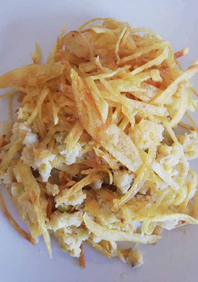 Una foto de Revuelto de bacalao con puerros y corona de patatas paja