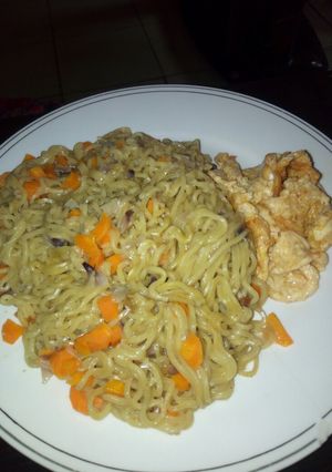 A picture of Noodles garnished with carrots fried egg.