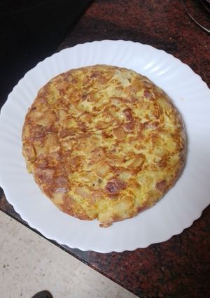 Una foto de Tortilla de papas con cebolla, fuet y perejil picado