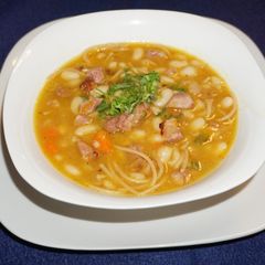 A picture of Great Northern beans with noodles and smoked ham.