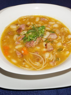 A picture of Great Northern beans with noodles and smoked ham.