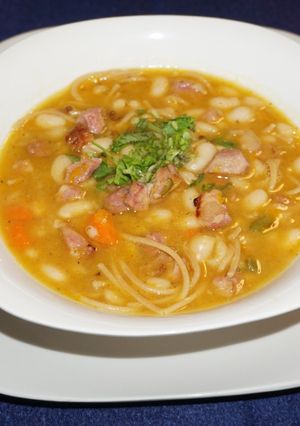 A picture of Great Northern beans with noodles and smoked ham.