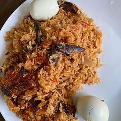 A picture of Jollof rice with smoked Hake fish.