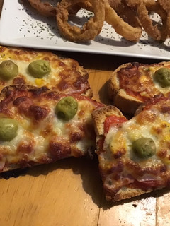 Una foto de Pan pizza/panini caseros con aros de cebolla 🍕🧅