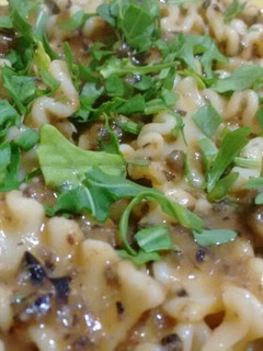Una foto de Pasta con salsa de alubias negras y rúcula con Agua de mar