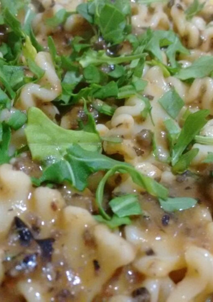 Una foto de Pasta con salsa de alubias negras y rúcula con Agua de mar