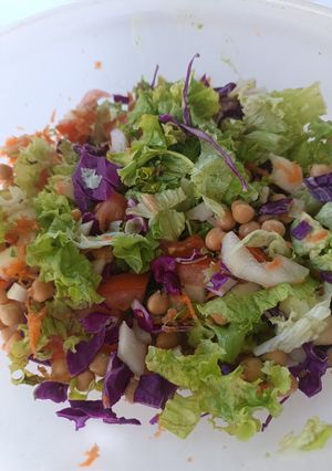 Una foto de Ensalada colorida de repollo morado, lechuga, tomate, pepino, zanahoria y garbanzos