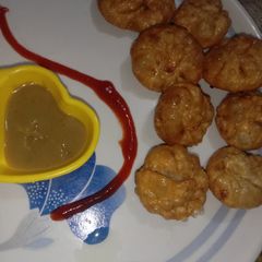 A picture of Street style veg fried momos with red chutney.