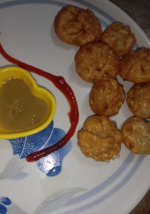 A picture of Street style veg fried momos with red chutney.