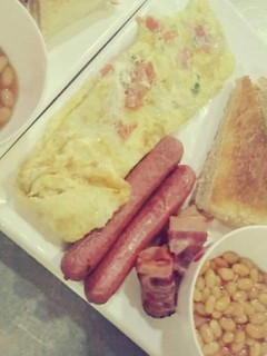 A picture of Omellete,sausages and baked beans.