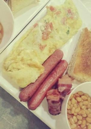 A picture of Omellete,sausages and baked beans.