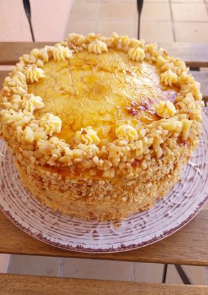 Una foto de Tarta de bizcochos relleno de frutas y crema con cobertura de crema quemada y crocanti
