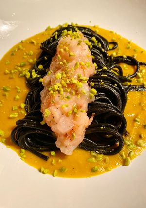 Foto di Spaghetti neri con crema di zucca, battuta di gamberi rossi e granella di pistacchi