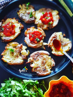 A picture of Crispy baked potatoes with garlic chilli schezwan sauce.