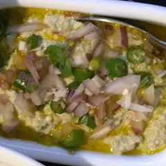 A picture of Posto Bhapa (Steamed Khus-Khus), with Mustard Oil.