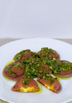 Una foto de Sorrentinos de zapallo en masa de remolacha con salsa pesto