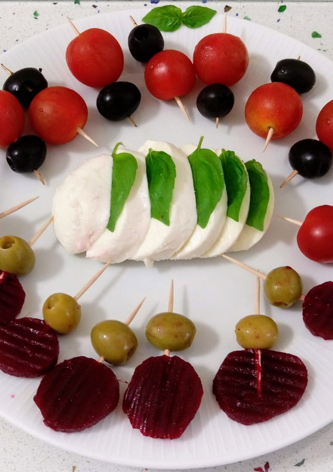 Una foto de Mozzarella con piruletas de remolacha y tomates cherry