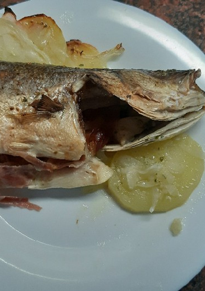 Una foto de Lubina al horno, con jamón serrano