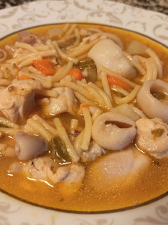 Una foto de Fideos gordos con pollo y calamares