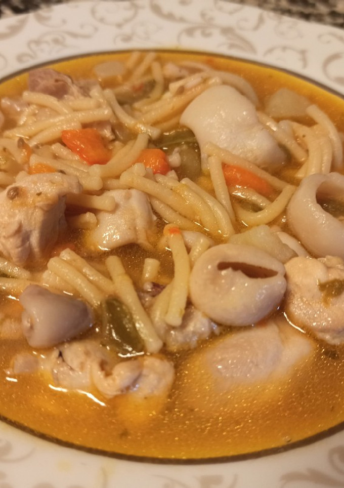 Una foto de Fideos gordos con pollo y calamares