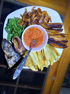 A picture of Fried sweet potatoes,plantain,fish with vegetable and pepper sauce.