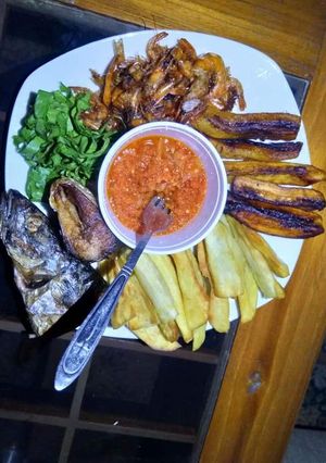 A picture of Fried sweet potatoes,plantain,fish with vegetable and pepper sauce.
