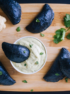 Una foto de Empanadillas negras rellenas de calamar y gambas con mayonesa de cilantro y jengibre