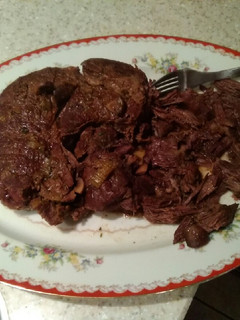 A picture of Braised beef over egg noodles/pot roast.