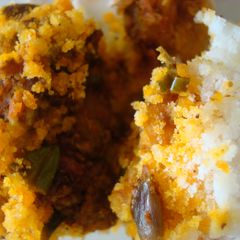 A picture of Steamed ground rice layered with prawn and coconut.