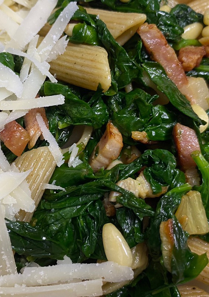 Una foto de Pasta con espinacas frescas, piñones, bacon y queso parmesano