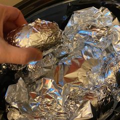 A picture of Slow cooker ribs and potatoes and corn on the cob.