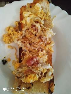 Foto principal de Tostada de pan con huevos revueltos con queso y jamón