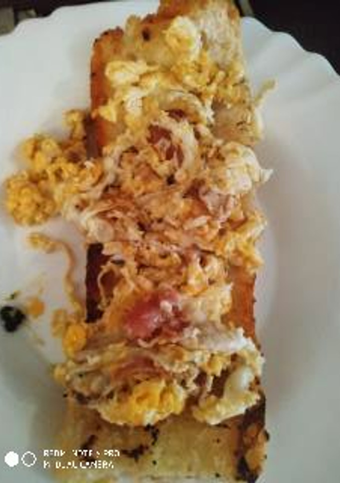 Una foto de Tostada de pan con huevos revueltos con queso y jamón