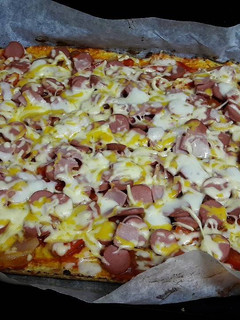 Una foto de Pizza con masa de coliflor de salchichas y queso
