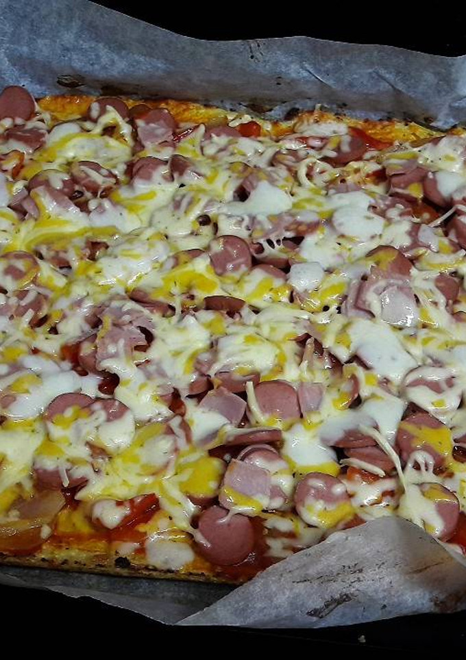 Una foto de Pizza con masa de coliflor de salchichas y queso