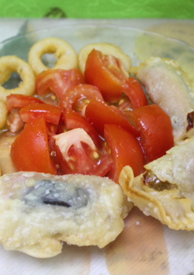 Una foto de Empanadillas de morcillas acompañada de calamares y tomate